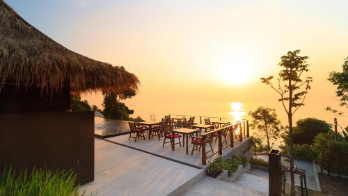 a deck with a table and chairs and the ocean at Sea Garden Resort Haad Chao Phao in Haad Chao Phao