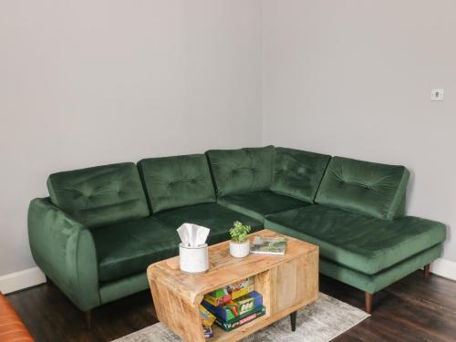 a green couch in a living room with a coffee table at 40 Main Street in Burntisland