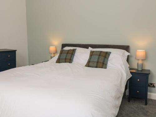 a bedroom with a white bed with two night stands at 40 Main Street in Burntisland