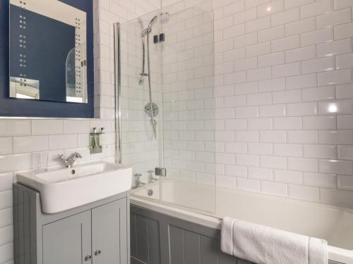 a white bathroom with a sink and a shower at 40 Main Street in Burntisland