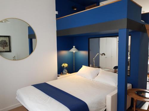 Brest : Beau T1 en centre ville في بريست: غرفة نوم بسرير ازرق وبيضاء مع مرآة