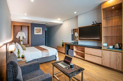 um quarto de hotel com uma cama e uma televisão de ecrã plano em Embledon Hotel em Ansan