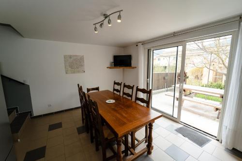 a dining room with a wooden table and a sliding glass door at Verdon Vacances in Saint-André-les-Alpes