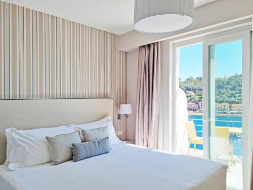 a bedroom with a bed and a large window at Hotel Plaza in Porto Azzurro