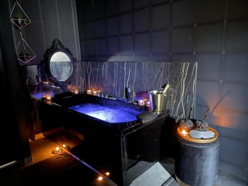 Maing的住宿－La Suite Maléfik，浴室配有带灯的浴缸。