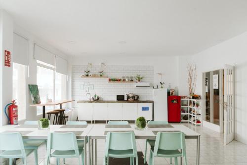 a kitchen with a table and chairs in a room at KYO Surf Hostel in Las Palmas de Gran Canaria