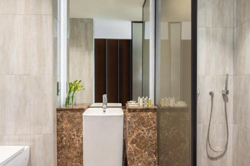 a bathroom with a shower and a toilet and a sink at voco Dubai Monaco, the Heart of Europe by IHG in Dubai