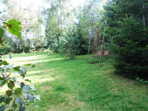 a yard with a swing set in the grass at Pokoje i apartamenty pod Jaworzyną w Koninkach in Koninki