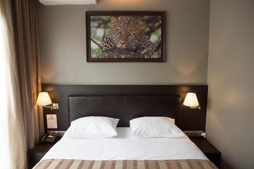 a bed with a picture of a leopard on the wall at Bartolomeo in Dnipro