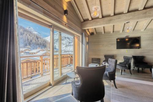 Cette chambre dispose d'une grande fenêtre offrant une vue sur les montagnes. dans l'établissement Victoria Lodge, Friendly Hotel, à Val dʼIsère