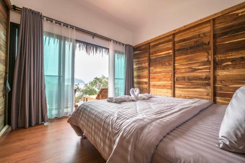 a bedroom with a large bed and a large window at Hidden Beach Resort in Ko Mak