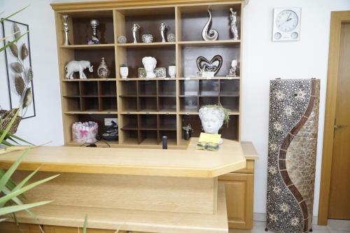 a desk in a room with a shelf of vases at Pension-Ferienwohnung Rotar in Faak am See