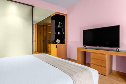 a bedroom with a bed and a flat screen tv at voco Dubai Monaco, the Heart of Europe by IHG in Dubai