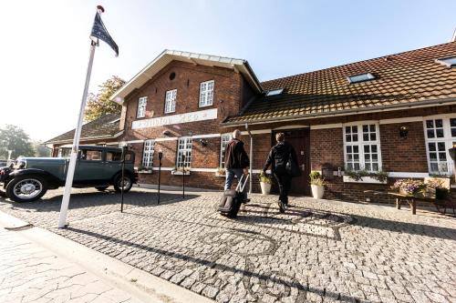 two people walking in front of a brick building at Filskov Kro in Grindsted