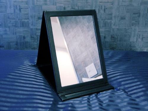 a black picture frame sitting on a bed at HOTEL LiVEMAX BUDGET Yumoto in Iwaki