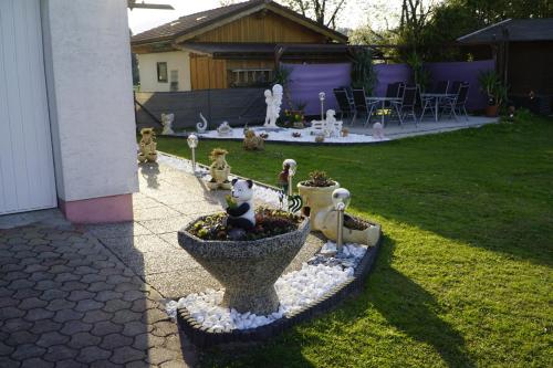 a garden with a bird bath with figurines in it at Pension-Ferienwohnung Rotar in Faak am See