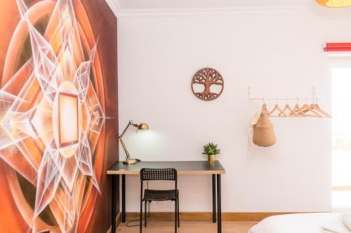 a desk in a room with a painting on the wall at Surf Yoga Ericeira Guest House in Ericeira