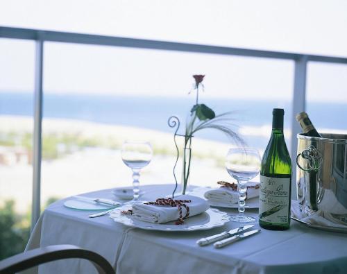 a white table with a bottle of wine and glasses at GRAND NIKKO AWAJI in Awaji