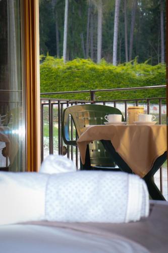 a table with cups on it next to a window at hotel Parco Pineta in Cavareno