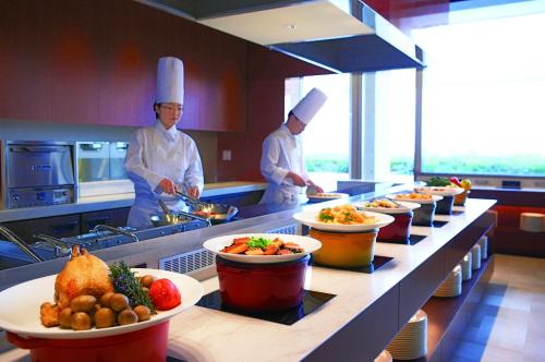 two chefs standing in a kitchen preparing food at GRAND NIKKO AWAJI in Awaji