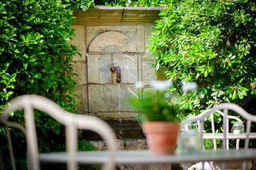 a stone door with a water fountain in a garden at La Maison du Village in Saint-Rémy-de-Provence