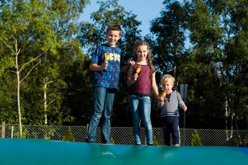 three children are standing on a trampoline at Filskov Kro in Grindsted