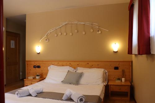 a bedroom with a bed with two night stands and two lights at hotel Parco Pineta in Cavareno