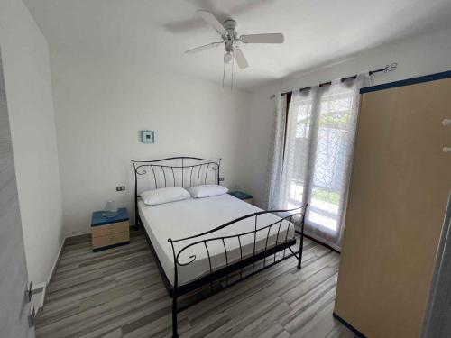 a bedroom with a bed and a ceiling fan at Holiday home in Isola Albarella 42378 in Isola Albarella