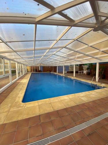 uma grande piscina com tecto retráctil em Apartamento Marexada Foz em Foz