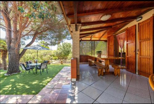 a patio with a table and chairs and an umbrella at Villa Lidia per una vacanza di relax in Solanas