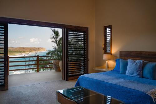 a bedroom with a bed and a view of the ocean at 2024 - Villa Serena in Santa Cruz Huatulco