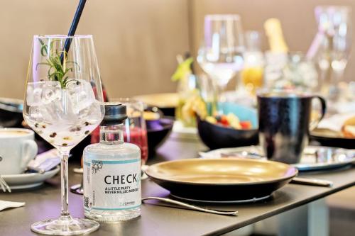 a table with a bottle of wine and a glass at Hotel Velden - 24 Checkin Zimmer im Zentrum in Velden am Wörthersee
