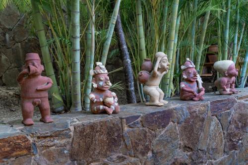 a group of statues sitting on a stone wall at 2024 - Villa Serena in Santa Cruz Huatulco