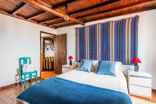 a bedroom with a blue and white bed and a chair at Casa das 10 Janelas @ Monsanto in Monsanto
