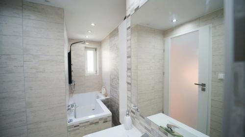 um banheiro com banheira, pia e banheira em Apartamenty EverySky - Konstytucji 3 go Maja 66-1 em Karpacz