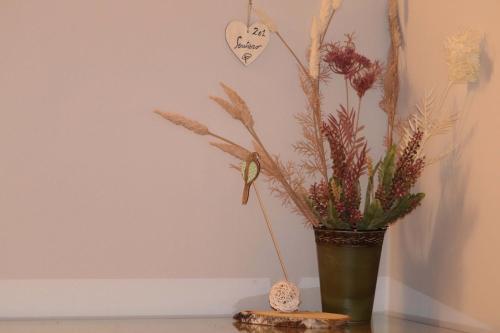 a green vase with a plant on a table at hotel Parco Pineta in Cavareno
