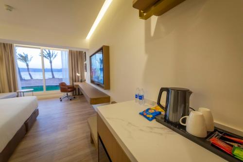 a hotel room with a bed and a kitchen with a counter at Luxotel Aqaba Beach Resort & Spa Only 15 years plus in Aqaba
