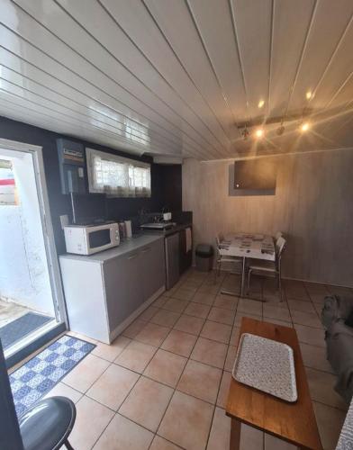 une grande cuisine avec une table et un comptoir dans l'établissement Studio Biarritz, à Biarritz