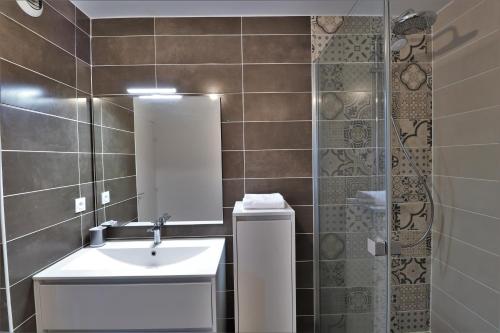 La salle de bains est pourvue d'un lavabo, d'un miroir et d'une douche. dans l'établissement LE BONDON, à Vannes