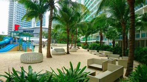 un complejo con un parque infantil con palmeras y un tobogán en Azure Urban Resort Staycation, en Manila