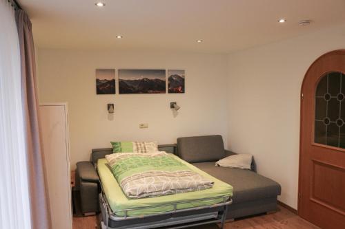 a small bedroom with a bed and a couch at Ferienwohnung Haus Hirschbichl in Berchtesgaden