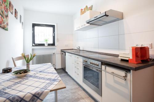 uma cozinha com uma mesa e um fogão forno superior em Ferienwohnung Wäller Sonnenschein em Westerburg