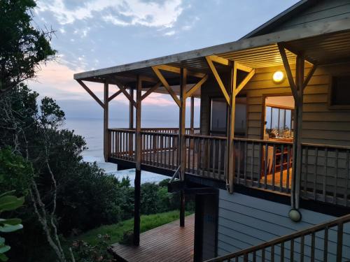 a house with a deck with a view of the ocean at Pequena Casa Holiday Home Malongane in Ponta Malongane