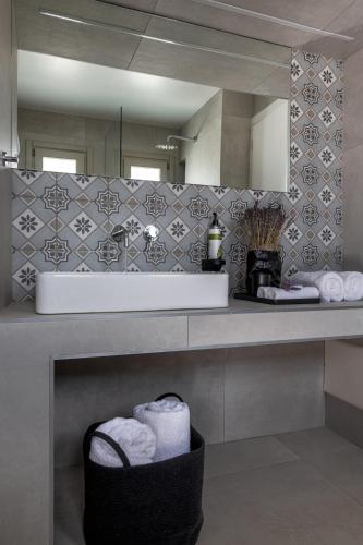 a bathroom with a sink and a counter with towels at NiMa Sifnos Residences in Apollonia