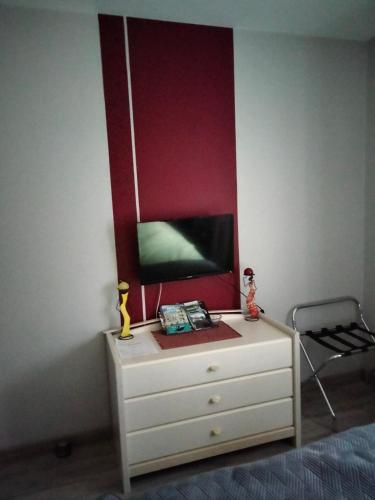 - une chambre avec une commode et une télévision murale dans l'établissement route departementale 765, à Pruniers