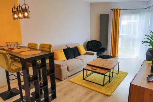 a living room with a couch and a table at APARTAMENT ELEGANCE YELLOW w Let's Sea Basen&SPA in Gąski