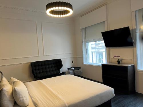 The Z Hotel Covent Garden في لندن: غرفة نوم بسرير وتلفزيون بشاشة مسطحة