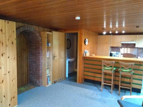 eine Küche mit Holzwänden und eine Bar mit Hockern in der Unterkunft Rieger FW 3 in Eckernförde