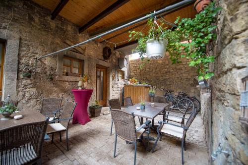 a patio with tables and chairs in a stone building at GoldGemäuer Appartements in Ochsenfurt