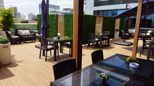 a patio with tables and chairs on a building at Skyna Hotel Luanda in Luanda